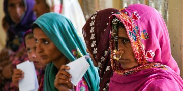 پانی سے گھرے ٹیلوں پر بیٹھی حاملہ عورتیں